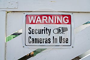 Destin, Florida- Sign with Warning Security Cameras In Use on a wooden gate