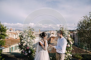 Destination fine-art wedding in Florence, Italy. Multiracial wedding couple. A wedding ceremony on the roof of the