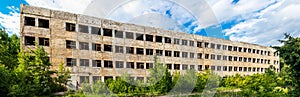 destroyed abandoned large concrete building on a summer day