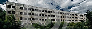 destroyed abandoned large concrete building on a summer day