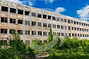 destroyed abandoned large concrete building on a summer day