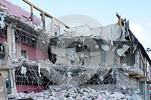 Destroyed apartment house. Lying armature, concrete, broken floors and roof. Dismantling the house construction