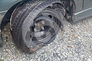 Destroyed blown out tire with exploded, shredded and damaged tire on a modern automobile. damaged truck rubber after tire explosio