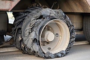 Destroyed blown tire with crushed and damaged rubber on a truck.