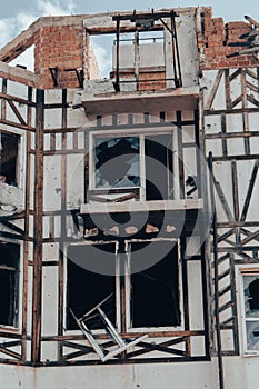 Destroyed building after russian invasion, Gostomel, Ukraine. Ruined facade of house with fachwerk design. War in Ukraine.