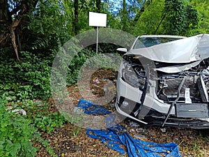 Destroyed car in car crash traffic accident on city road. Smashed broken front, left in the wasteland. Auto life and insurance