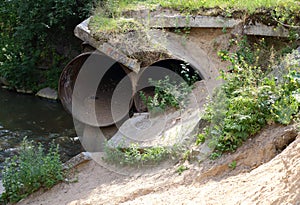 Destroyed channeling metal pipes of a large deameter near the river photo