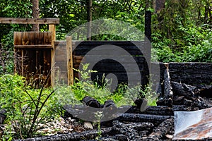 Destroyed by fire wooden house completely burned to the ground .ruins of a burnt wooden house after a fire