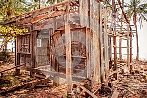 Destroyed home at coast , wooden hut ruin / destroyed house made of wood