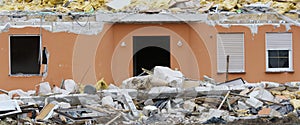 Destroyed house with wreckage in foreground in panoramic format