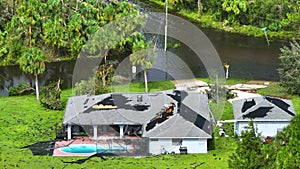 Destroyed by hurricane Ian private house with damaged rooftop and swimming pool lanai enclosure in Florida residential