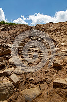 Destroyed Mountain Road with Stones and Dirt