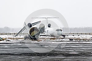 Destroyed old aircraft in the landfill at the airport in winter.