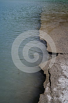 Destroyed road going under the water during flooding