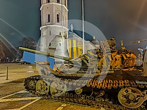 A destroyed Russian tank standing at night in the old town of Vilnius