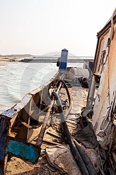 Destroyed and rusty deck of a cargo ship with old bridge, machinery and equipment, washed ashore