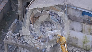 Destroying Old Concrete House Using Mechanical Arm of Bulldozer on Construction Site