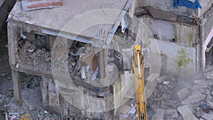 Destroying Old Concrete House Using Mechanical Arm of Bulldozer on Construction Site