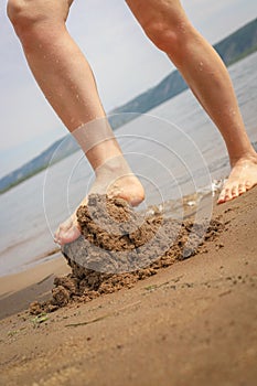 Destroying sandcastle by stomping on it