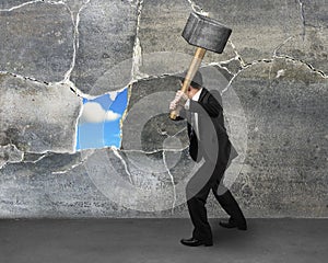 Destructing the wall with a large hammer