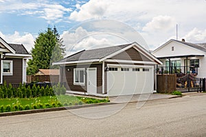 Detached garage of residential house with asphalt road in front.