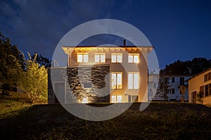 Detached house just renovated, with modern finishes. Back of the house with large private green garden at night photo