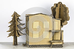A detached house and trees, all made of cardboard