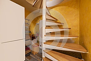detached house with two floors with a spiral staircase of wood and white mental and a pantry with a fridge