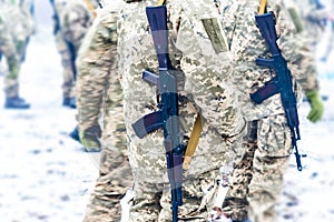 A detachment of soldiers with Kalashnikov assault rifles stand in formation to prepare for battle and offensive