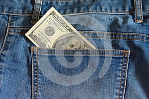 Detail of 100 dollar note in the pocket of blue jeans