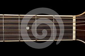 Detail of a 12 string guitar fretboard on black background