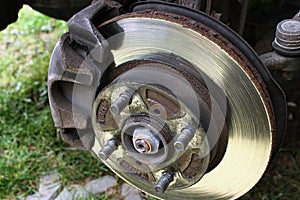 Detail of 13 years old rusty brake rotor and caliper assembly after wheel disc removal.