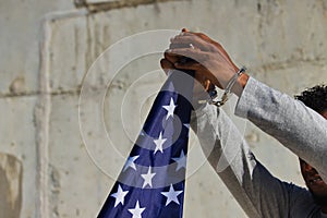 Detail of african american hands in shackles clutching a united states flag. Racial repression