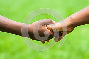 Detail of African kids holding hands.