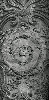 Detail on an ancient column with some floral creature photo