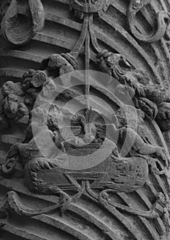 Detail on an ancient column with some winged creatures photo