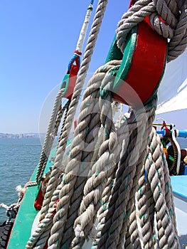 Detail of ancient pulleys and ropes or cords on the prow or bow of the sailboat Amoroso, a historical, typical or traditional