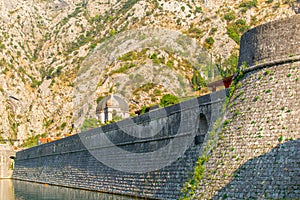 Detail of the ancient stone wall of the Gurdic Gate near the pond water in the old town of Kotor, Montenegro