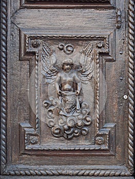 Angel carved on the wooden portal of an ancient Italian church