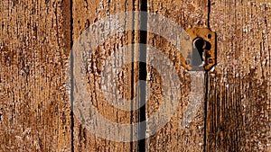 detail of antique lock on brown wooden door