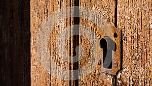 detail of antique lock on brown wooden door