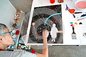 Detail of paint brushes and bright paint in an artistÃ¢â¬â¢s studio photo