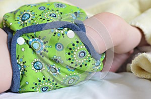 Detail of babyÂ´s hip dressed in green cloth diaper