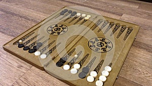 Detail of a backgammon game with two dice close up. Male hands rolling two dice and moving checkers on board.