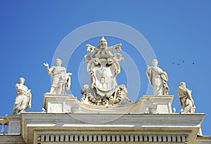 Detail from baroque Saint Peter`s colonnade with beautiful statues of saints and Pope Alexander VII coat of arms. Vatican City