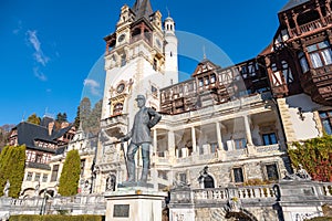 Detail of beautiful Peles Castle in Sinaia with the statue of King Carol I of Romania in front.