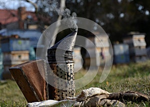 detail of beekeeper smoker to calm bees in beehive metal smoke early morning frame with honeycomb sun