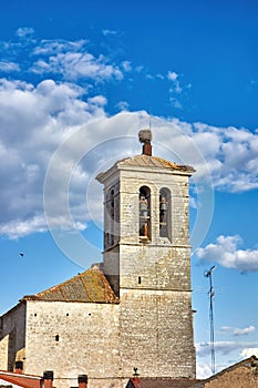 Detail of the bell tower of a rural church with stork nests on its roof