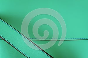 Detail of genuine grainy leather of light mint green color, leather handbag. Texture and fashionable modern background