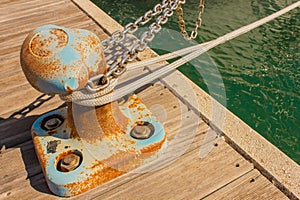 Detail of a bitt with chains and ropes for mooring at the harbor